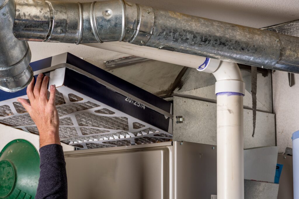 Technician replaces a furnace filter with a clean one